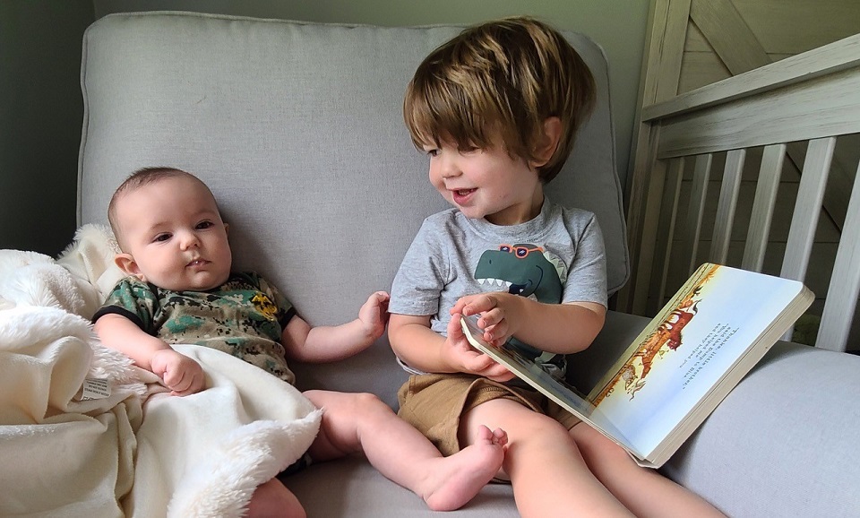 Big Brother Reading to Younger New Born Brother
