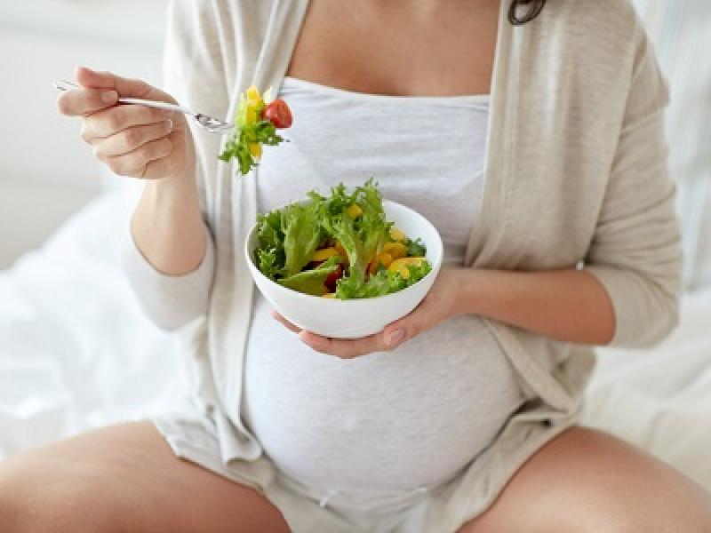 Pregnant woman eating healthy salad 