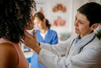 Female doctor checking female patient thyroid
